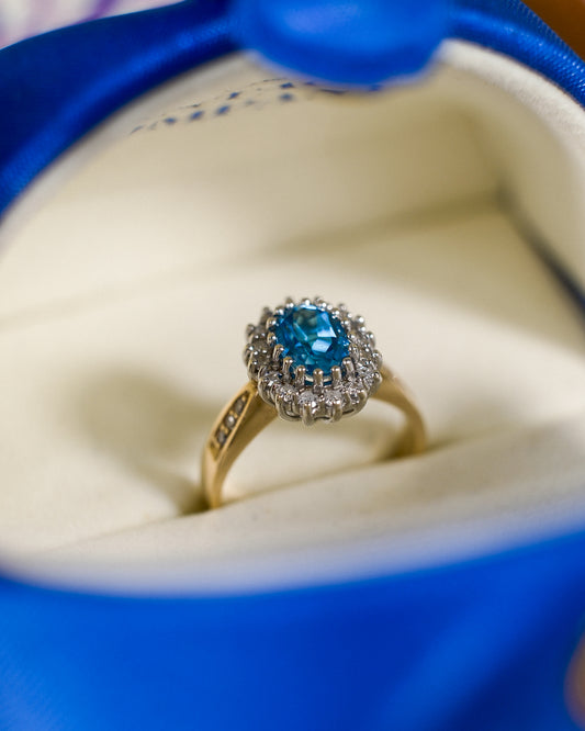 Een vintage ring met een blauwe topaas en diamanten van 9k geelgoud, product foto van de lijn Milena van The Vintage Company
